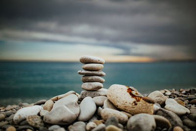 Stack of stones on beach against sky