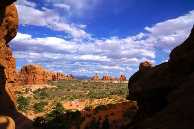 Rock formations on landscape against cloudy sky