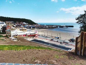 Scenic view of beach by buildings against sky