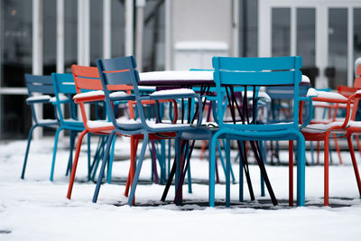 Empty chairs and tables at sidewalk cafe