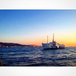 Boat sailing in sea at sunset