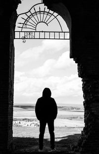 Rear view of silhouette man standing on beach