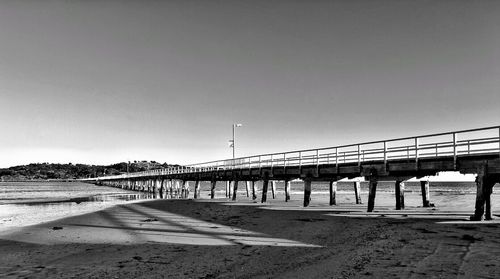 Bridge over sea against clear sky