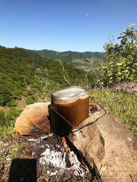 Container on bonfire against mountains