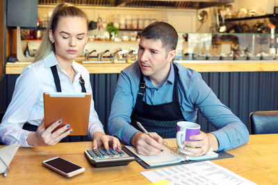 Young man using smart phone on table