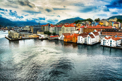 Aerial view of townscape by sea against sky