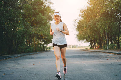 Full length portrait of woman standing on road