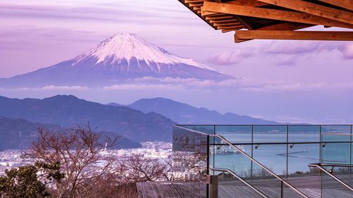 Scenic view of sea by snowcapped mountains against sky