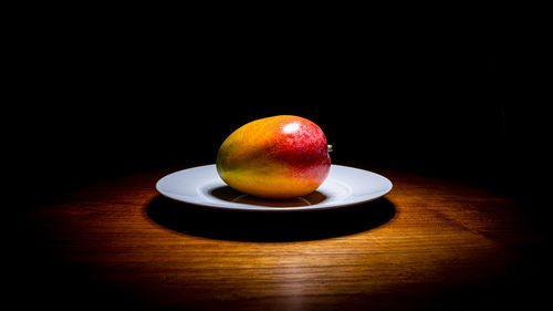 Close-up of apple on table against black background