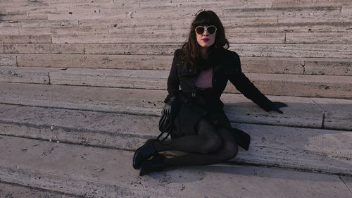 Portrait of woman sitting on wall
