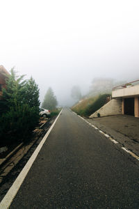 Road by trees against sky