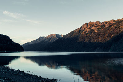 Scenic view of lake by mountains against sky