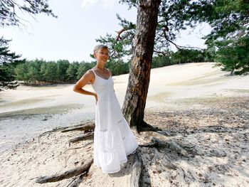 Woman standing on field by tree