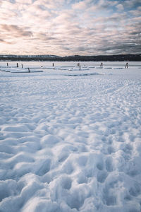 Scenic view of frozen lake against sky during sunset