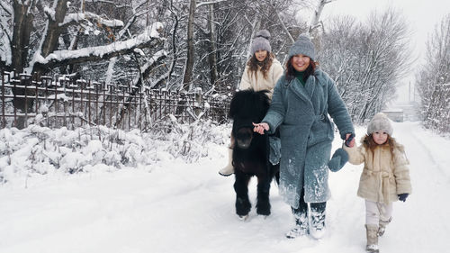 Rear view of couple standing on snow covered field