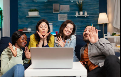 Friends waving on video call on laptop