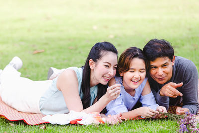 Portrait of friends relaxing on field