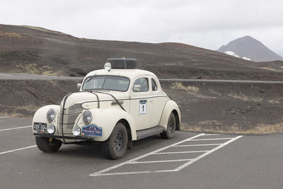 Vintage car on road against mountain range