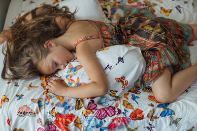 High angle view of girl lying on bed at home