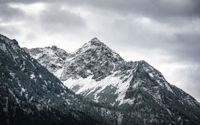 Low angle view of snowcapped mountain against sky