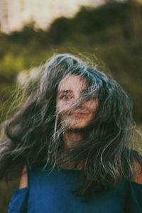 Close-up portrait of woman with tousled hair outdoors