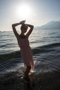 Rear view of woman standing at beach