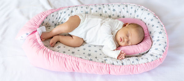 High angle view of cute baby sleeping on bed