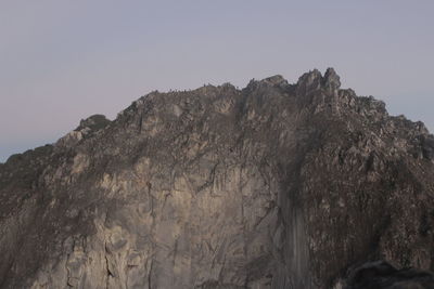 Low angle view of rocky mountains against clear sky