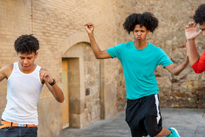 Group of afro latin male friends dancing in the street