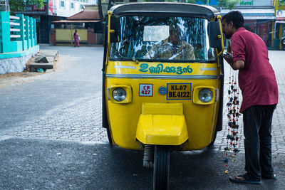 Rear view of man standing on road in city