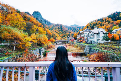 Rear view of woman looking at mountain during autumn