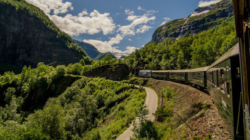 Scenic view of road amidst mountains against sky