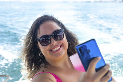 A woman on top of a boat against the sea in the background. 