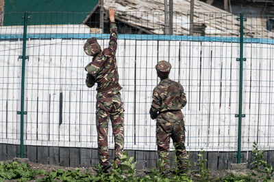 Full length of man standing against fence