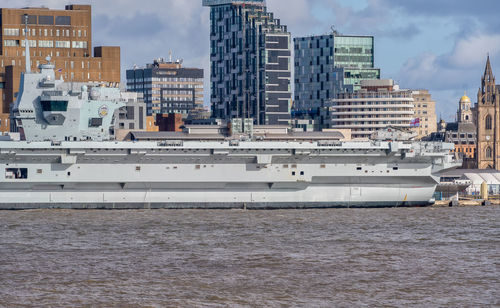 View of city buildings by sea against sky