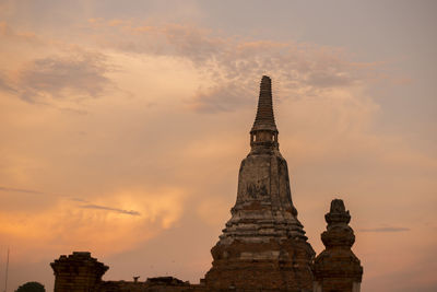 Low angle view of wat mahathat against sky during sunset