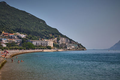 Scenic view of sea by buildings against sky