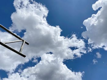 Low angle view of telephone pole against blue sky