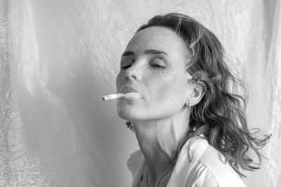 Close-up portrait of woman smoking cigarette