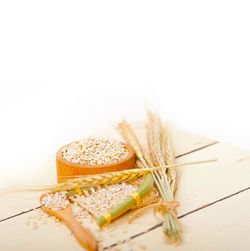 Close-up of wheat on table against white background