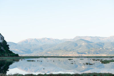 Scenic view of lake and mountains against clear sky