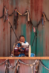 Full length of man sitting on chain