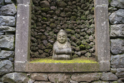 Statue against stone wall