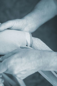 Cropped hands of doctor holding patient hand in hospital