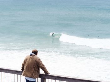 Rear view of man looking at sea