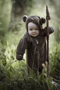 Baby girl wearing costume standing on field