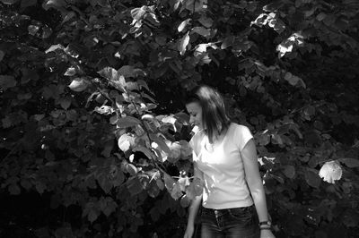 Woman looking at leaf while standing