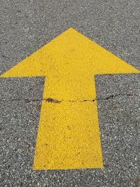 Close-up of yellow arrow symbol on road