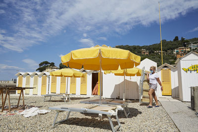 Rear view of man standing on beach against sky