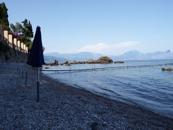 Scenic view of beach against clear blue sky